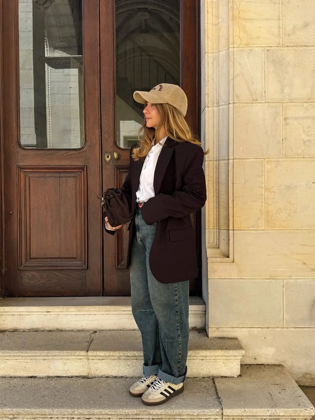 Оверсайз-блейзер у streetstyle Темно-коричневий оверсайз-блейзер, біла сорочка та широкі світлі джинси з кепкою